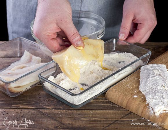 Обмакните каждое филе трески сначала в яйцо, затем — в мучную панировку.