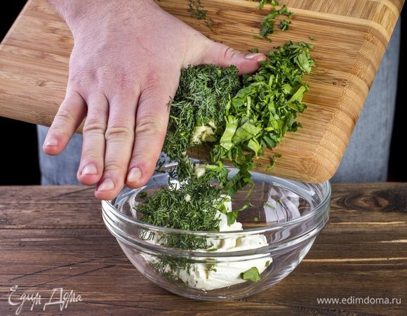 Приготовьте начинку, смешав творожный сыр, измельченные зелень, чеснок и сметану.