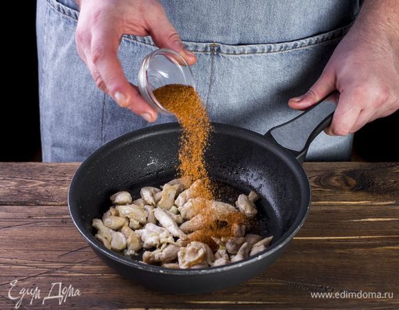 Обжарьте кусочки курицы на сковороде со специями до золотистой корочки.