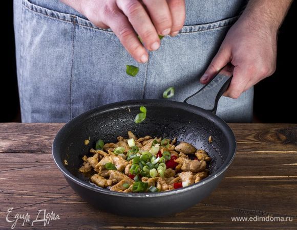 К куриному филе добавьте рубленый чеснок, перец чили и зеленый лук.