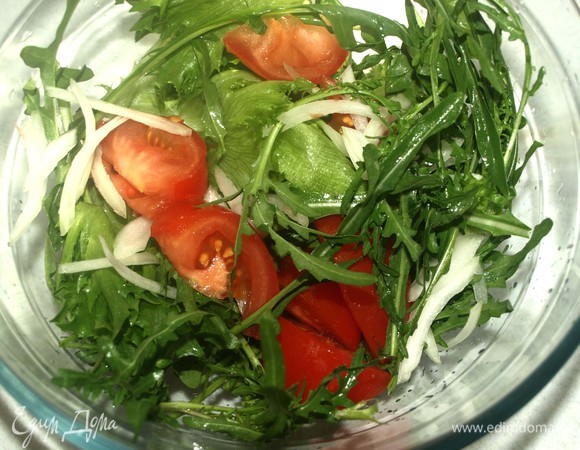 Руколу и фриллис промыть, дать стечь воде. Выкладываем салат в миску. Добавляем нарезанный дольками помидор, тонко нарезанный перьями лук.