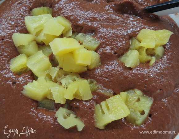 Добавить какао, разрыхлитель и соду, взбить до однородности. Ананас порезать на кусочки. Можно также взять консервированные ананасы в собственном соку (сейчас в продаже есть варианты консервации без содержания сахара). Добавить кусочки ананаса в шоколадное тесто, перемешать лопаткой.