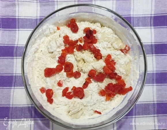 Всыпаем вяленую вишню и постепенно добавляя муку замешиваем тесто. Муки может потребоваться чуть меньше или больше указанного количества.