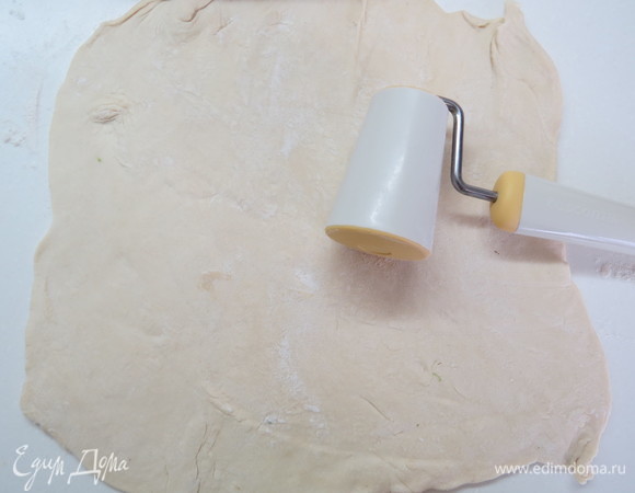 Раскатать один пласт слоёного бездрожжевого теста на поверхности, слегка присыпанной мукой.