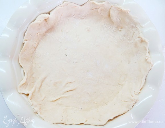 Включите духовку на 170°C. Перенесите раскатанный пласт теста в форму. Наколите вилкой в нескольких местах.