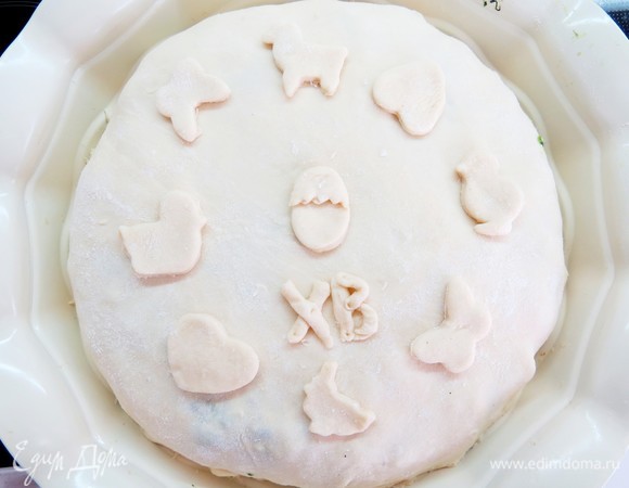 Поверх яиц кладем оставшуюся часть шпинатной начинки. Раскатываем второй пласт теста и накрываем пирог. Для румяности можно смазать пирог желтком.