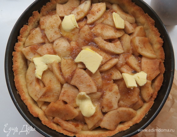 Достать форму из духовки, выложить в нее тушеные яблоки вместе с яблочным соком. Сверху положить хлопья сливочного масла, всего уйдет примерно 1 ст. л. масла. Поместить в духовку и выпекать ~15–20 минут.