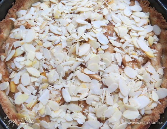 Затем достать пирог из духовки, посыпать верх миндальными лепестками и снова отправить в духовку до готовности еще минут на 10–15.