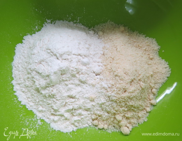 Масло надо заранее достать из холодильника, оно должно быть комнатной температуры. Смешать миндальную муку с мукой пшеничной.