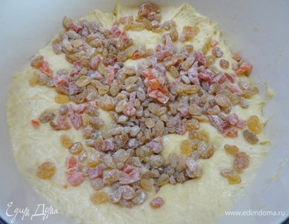 В подошедшее тесто добавить смешанный с мукой изюм и хорошо перемешать.