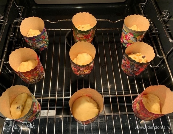 Немного обомните тесто. Разделите на части и положите в формы для выпечки. Тесто должно занимать примерно 1/3 часть формы. Поставьте на расстойку в теплое место минут на 30.