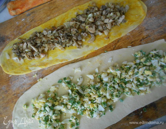 Каждую часть подошедшего теста раскатываем в прямоугольный пласт шириной 10, длиной 60–70 см. На желтую часть теста выкладываем грибную начинку, на белую-яично-луковую, на тесто с паприкой-сырную начинку.