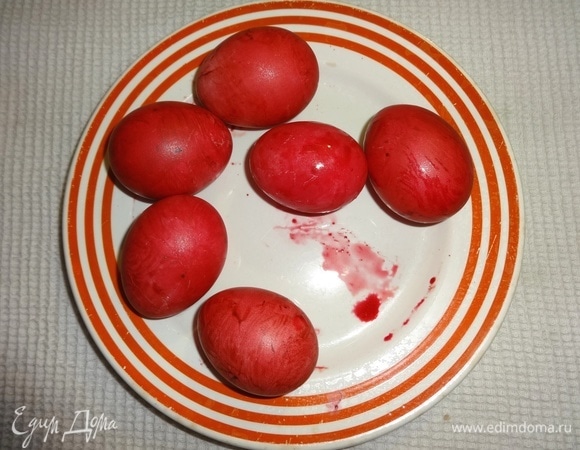 С помощью кисточки покрасить горячие и насухо протертые яйца красным пищевым красителем.