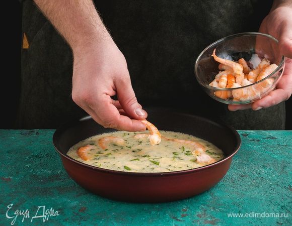 Форму для выпекания смажьте сливочным маслом. Выложите яичную смесь. Добавьте очищенные креветки.