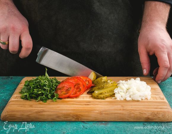 Нарежьте помидоры, лук, петрушку, огурцы.