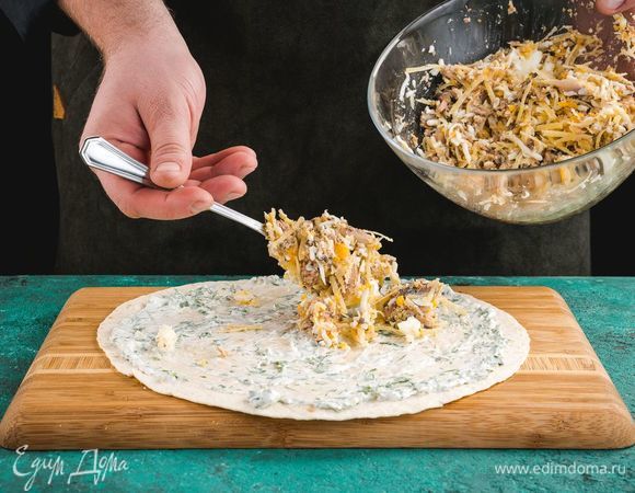 Разложите тортилью, смажьте майонезом с чесноком и зеленью. Сверху выложите начинку из сайры с яйцом и сыром.