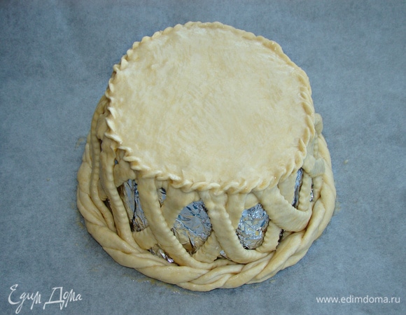 Затем так же по кругу уложить полоски, но в обратном направлении. Сверху все накрыть вторым кругом из теста. Края хорошо закрепить. Низ чаши оформить жгутом, скрученным из полосок теста. Чашу смазать взбитым яйцом и поставить в разогретую до 180°C духовку примерно на 25–30 минут до румяного цвета.