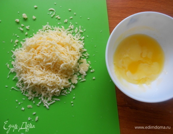 Подготовить ингредиенты. В теплое молоко добавить сыворотку, сахар, дрожжи, 2 ст. л. муки, перемешать и оставить в теплом месте до образования пенной шапочки. Сыр натереть на мелкой терке. Сливочное масло растопить. Отделить желток от белка.