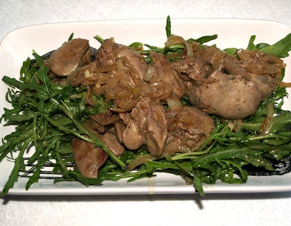 На тарелку выкладываем руколу, поливаем заправкой. Выкладываем печень с луком.