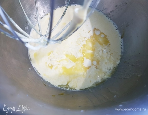 Влить растопленное сливочное масло, теплое молоко, опару и перемешать.