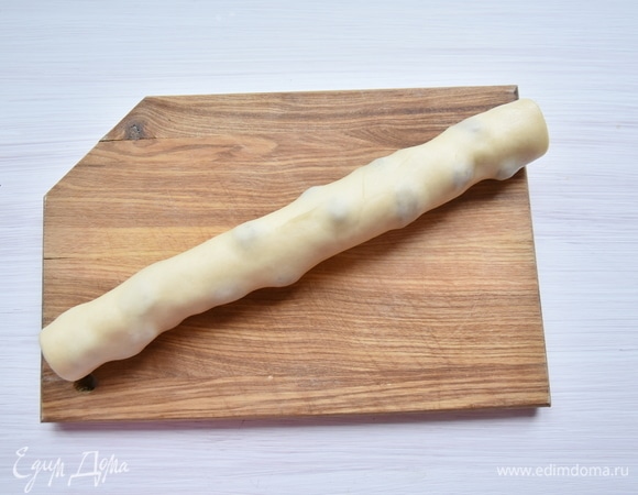 Каждую часть округлить, выложить на доску, накрыть пленкой и дать заготовкам еще подойти (30 минут). Через положенное время раскатать заготовку как можно тоньше. Смазать тесто пятой частью мягкого сливочного масла. Разложить клюкву и посыпать щепоткой молотого мускатного ореха. Свернуть тесто в неплотный рулет. Таким же образом поступить со всеми заготовками теста. Накрыть рулеты пленкой и оставить их еще на 30 минут.