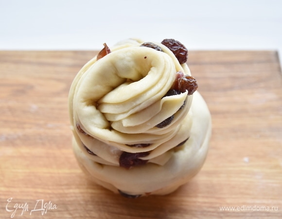 Рулет разрезать вдоль, оставляя неразрезанным один конец. Скрутить тесто в виде улитки, стараясь выворачивать слои наружу. Конец теста заправить в центре внутрь краффина.