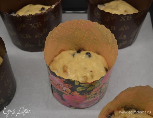 Добавить в тесто сухофрукты, вымесить и разложить по формам, заполняя их чуть меньше, чем на половину. Накрыть и дать расстояться около 2,5 часов до увеличения в объеме.
