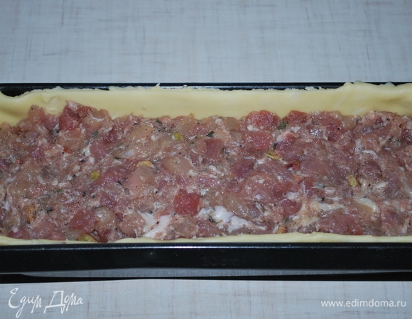 Форму для выпекания смажьте растительным маслом. Раскатайте тесто в пласт, выложите в форму таким образом, чтобы полностью закрыть дно и стенки формы. Форму с тестом заполните начинкой.