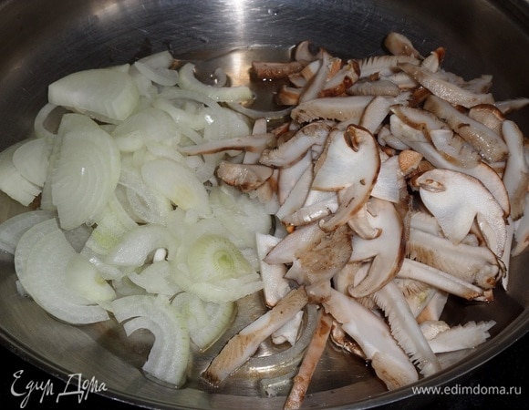 В разогретую сковороду наливаем растительное масло. Выкладываем лук и грибы. Перемешиваем.