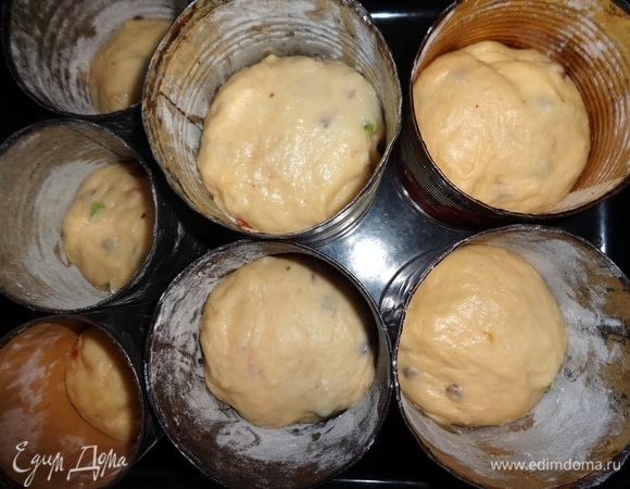 Подготовить формы для выпекания. На дно форм выложить кружки из бумаги, смазать дно и бока растительным маслом. Обсыпать мукой, излишки муки удалить. Тесто обмять. Разделить на части и выложить в подготовленные формы на 1/2 или на 1/3 объема формы.