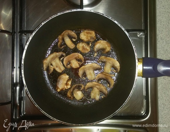 Смазываем сковородку оливковым маслом и обжариваем на ней шампиньоны (с каждой стороны по 2 минуты).