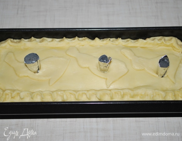 В каждое отверстие вставьте воронку из фольги, потом будет удобно наливать бульон через них. Поставьте пирог в разогретую духовку при температуре 160–170°C на 1 час 30 минут.