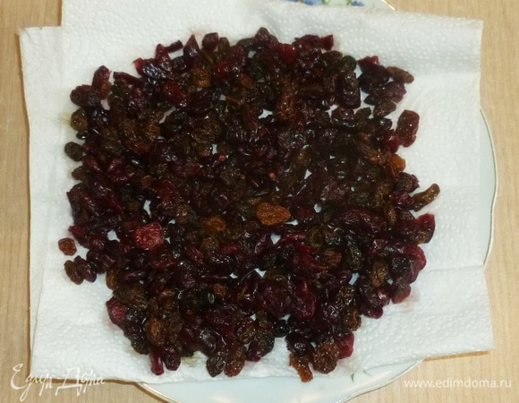Изюм и клюкву промыть, откинуть на сито и разложить на бумажном полотенце.