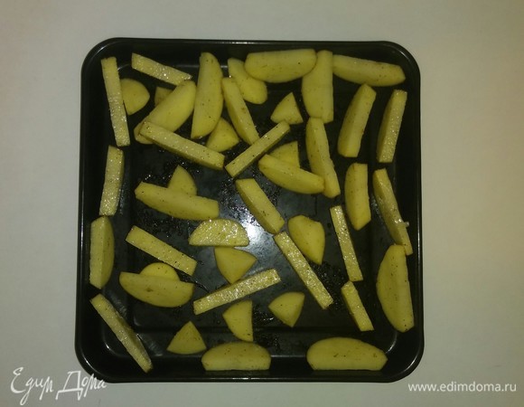 Берем противень, в котором будем запекать картошку. Дольки картошки ставим вертикально кожурой вниз, чтобы они не пригорали. Желательно, чтобы дольки картошки не касались друг друга — так они лучше пропекутся. Разогреваем духовку до 195°C и ставим в нее противень с картофельными дольками на 45 минут (время приготовления зависит от духовки). Степень готовности можно проверить щупом для пирога или зубочисткой. Приятного аппетита!