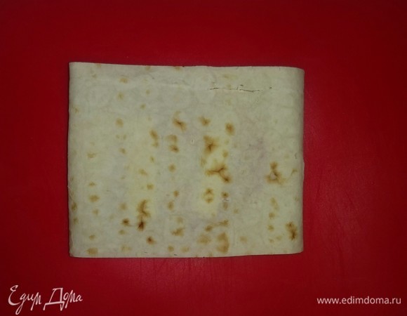 Затем сворачиваем полоску лаваша. С остальными полосками лаваша поступаем так же.