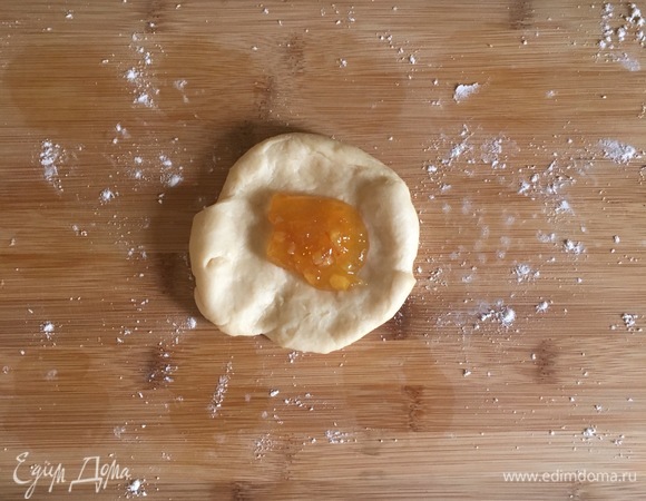 Далее начиняем булочки джемом: раскатать скалкой шарик, положить в центр 1–2 ч. л. джема, края собираем кверху и хорошо защипываем.