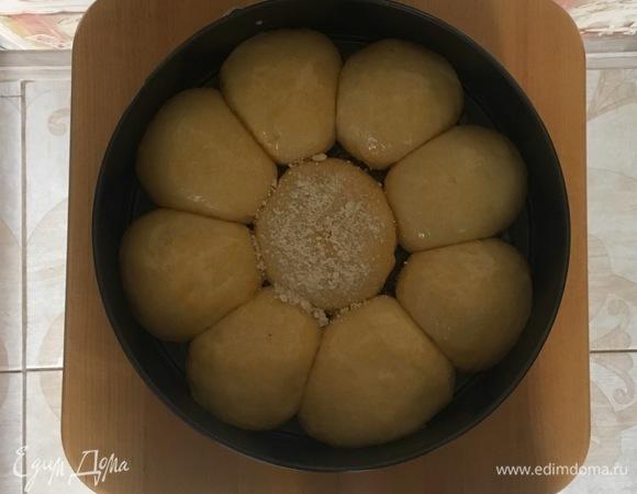 Булочки увеличились вдвое и соединились друг с другом, получилась так называемая ромашка. Булочки смазать взбитым яйцом.