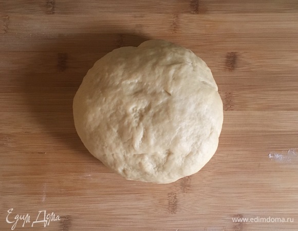 Выложить тесто на посыпанный мукой стол и вымесить в течение 7–10 минут. Получается гладкое нежное, не липнущее к рукам тесто. Переложить тесто в смазанную сливочным маслом миску, накрыть пищевой пленкой и оставить на 1 час в теплом месте.