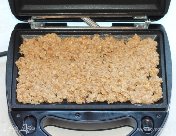 Выложить геркулесовую смесь на нижнюю панель прибора мультипекаря и закрыть крышку. Включить мультипекарь. И через несколько минут (5–7 минут) загорается зеленый свет.