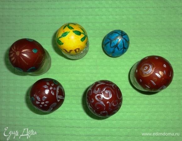 Каждое яйцо поставить на подставку и расписать. В качестве подставок я использовала маленькие рюмочки и пластиковые крышки от бутылок. Дать расписанным яйцам полностью высохнуть. Если хотите нанести краску поверх другой краски, дождитесь полного высыхания предыдущей.