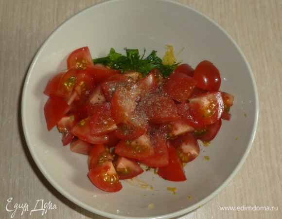 К чесночной смеси добавить орегано и рубленую петрушку. Помидоры нарезать небольшими кусочками, добавить в миску, перемешать.