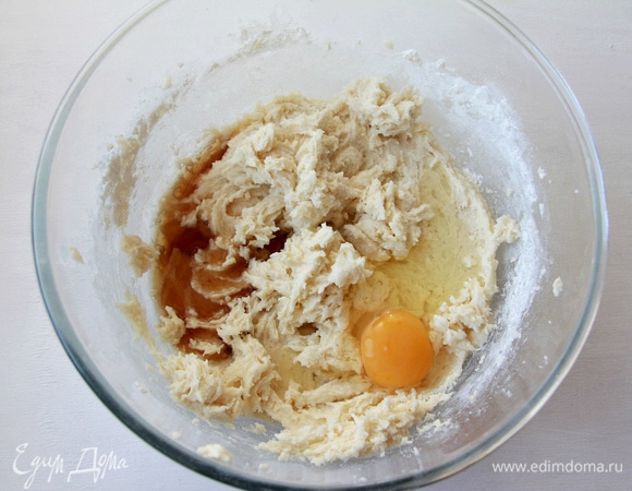 Не прекращая взбивать, ввести в тесто ром, экстракт миндаля и одно яйцо.