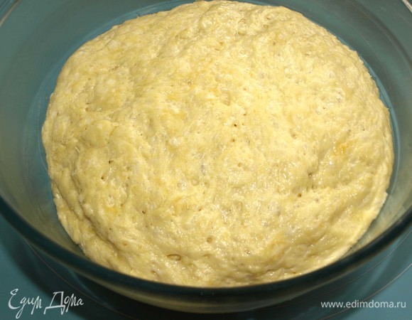 Через час тесто увеличится в объеме. Перекладываем тесто на посыпанную мукой рабочую поверхность. Приминаем руками. Духовку разогреваем до 180°C. 