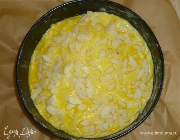 Оставшееся тесто немного раскатать и накрыть пирог, края залепить. Форму накрыть полотенцем и оставить на 1 час. Смешать молоко и желток, смазать пирог. Посыпать миндальными лепестками.