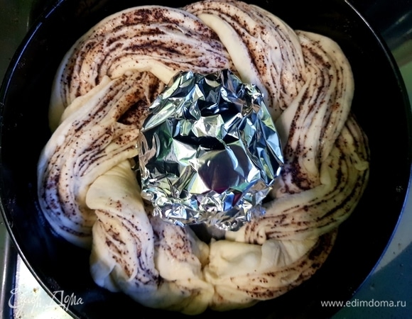Выложить косу по кругу в форму с бортами, соединить два края. В середину положить шар из фольги и оставить в теплом месте на 15 минут.