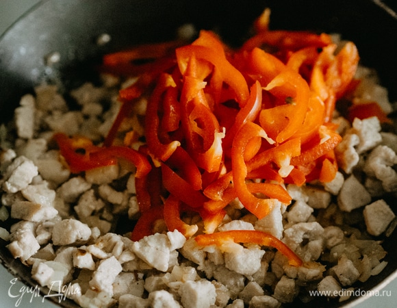 Выкладываем отдельно лук и тушим до золотистого цвета. Затем добавляем ранее приготовленные кусочки индейки. Тушим 2 минуты, затем добавляем болгарский перец. Снова тушим 2 минуты, постоянно помешивая.