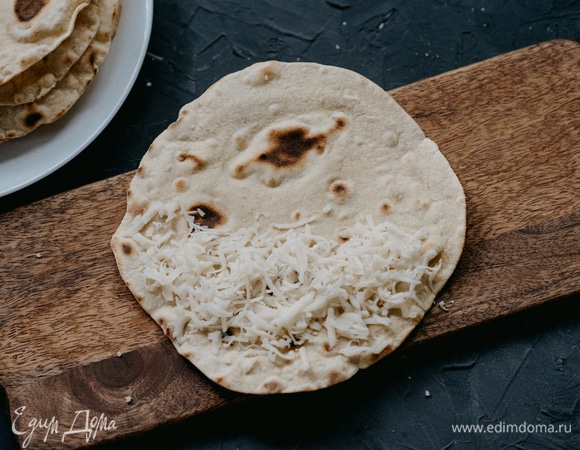 Итак, пора собирать нашу кесадилью. Кладем тортилью на ровную поверхность, на одну ее половину выкладываем часть сыра, равномерно распределяем.