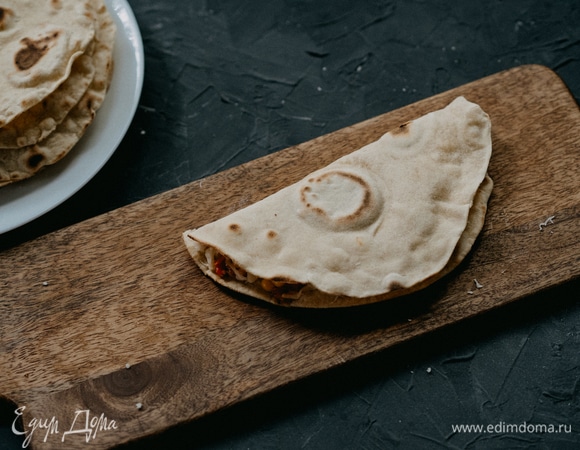 Складываем тортилью пополам, немного прижав ладонью сверху. Теперь надо перенести почти готовую кесадилью на чистую сковороду без масла для того, чтобы сыр расплавился. Для обжарки каждой стороны хватит по 1 минуте. Можно аккуратно заглядывать внутрь и проверять, расплавился ли сыр.