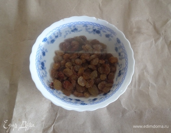 Изюм промываем и заливаем горячей водой. Оставляем на 5 минут. Затем воду сливаем. Изюм обсушиваем.