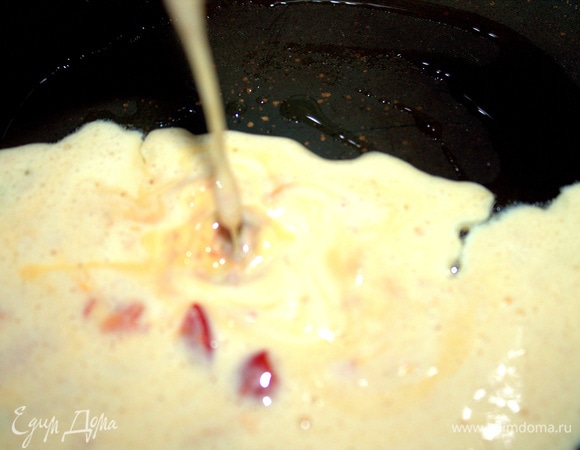 Добавить томат в омлетную массу и вылить в смазанную сковороду диаметром 20 см или больше.